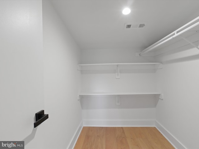 walk in closet with hardwood / wood-style flooring