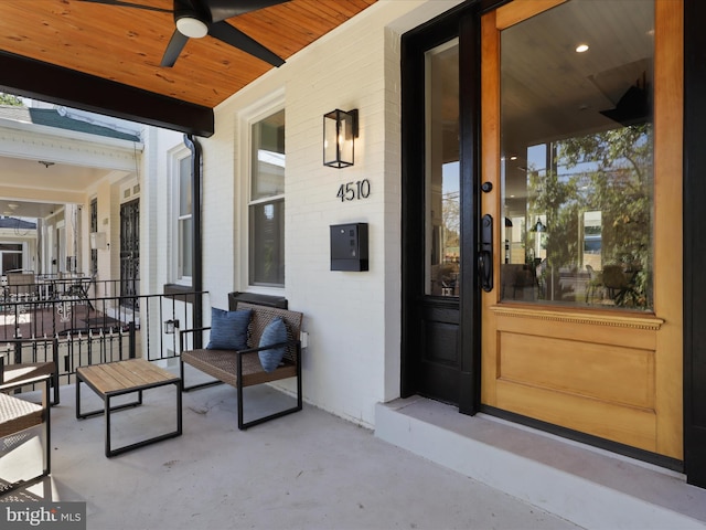 entrance to property with ceiling fan and a porch