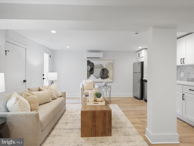 living room featuring a wall mounted air conditioner and light wood-type flooring