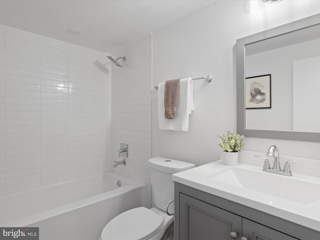 full bathroom featuring vanity, tiled shower / bath combo, and toilet