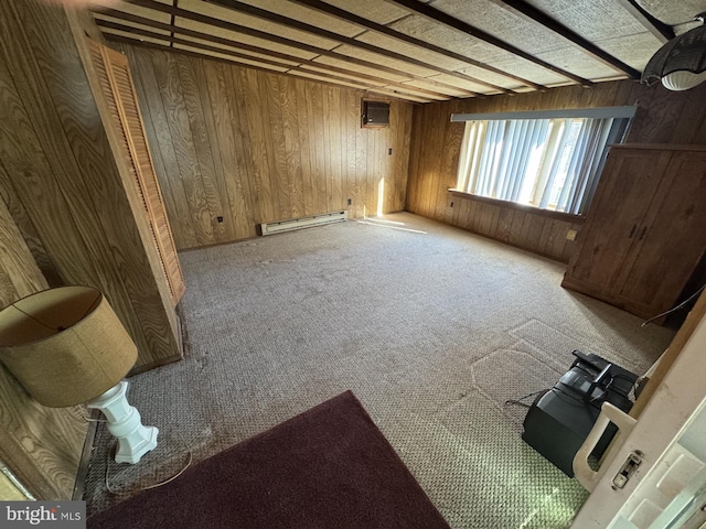 spare room with carpet, a wall mounted AC, wooden walls, and a baseboard radiator