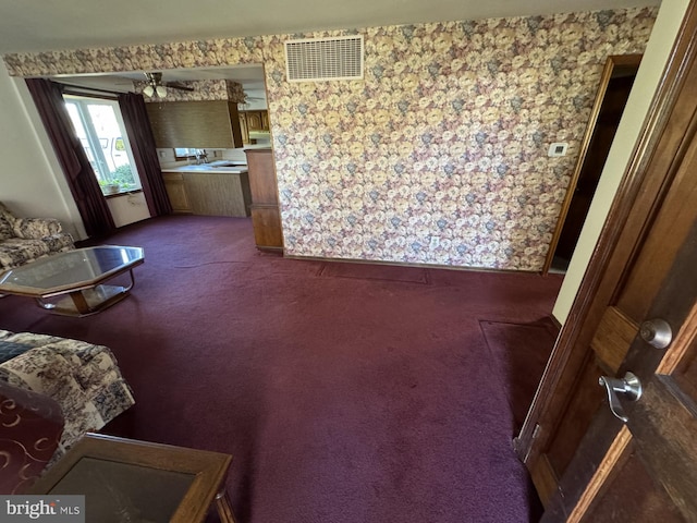 carpeted living room with ceiling fan and sink