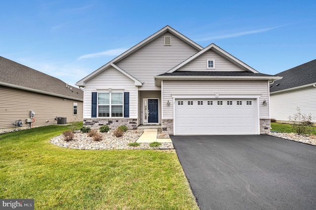 craftsman-style home featuring cooling unit, a front yard, and a garage