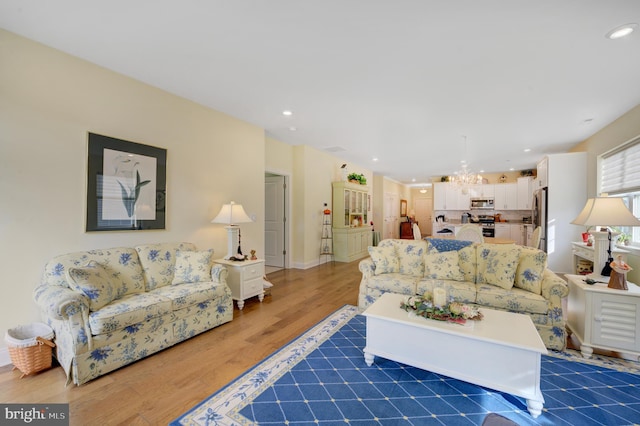 living room with an inviting chandelier and dark wood-type flooring