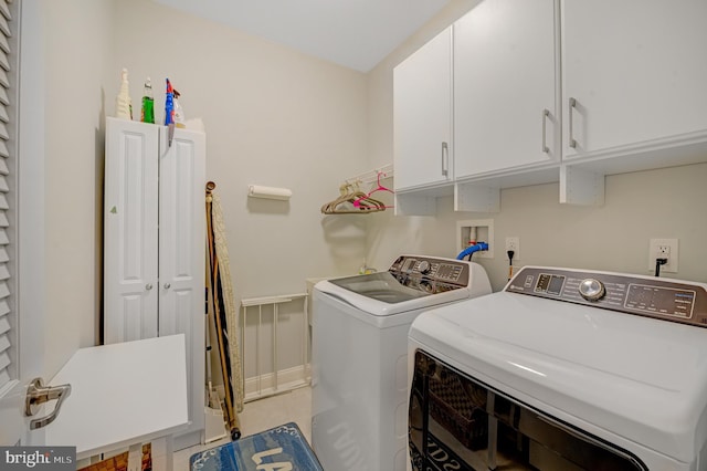 laundry area featuring washer and clothes dryer and cabinets