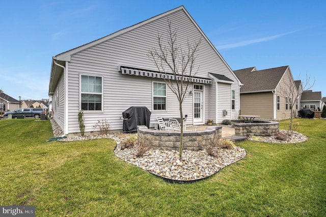 back of house featuring a yard, a patio, and a fire pit