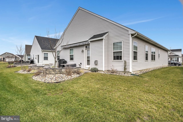 back of property with a lawn and a patio area