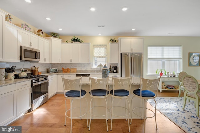 kitchen with appliances with stainless steel finishes, a center island, and plenty of natural light