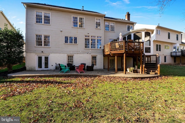 back of property featuring a yard, a wooden deck, a patio area, and french doors