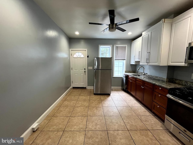 120 S Haven St, Baltimore, MD 21224 - kitchen with appliances with stainless steel finishes, a sink, a ceiling fan, white cabinets, and light tile patterned floors