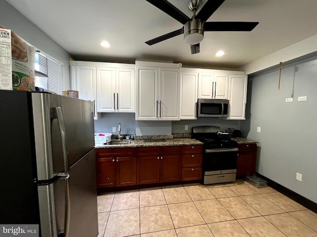 kitchen with ceiling fan, sink, stainless steel appliances, light tile patterned floors, and white cabinets