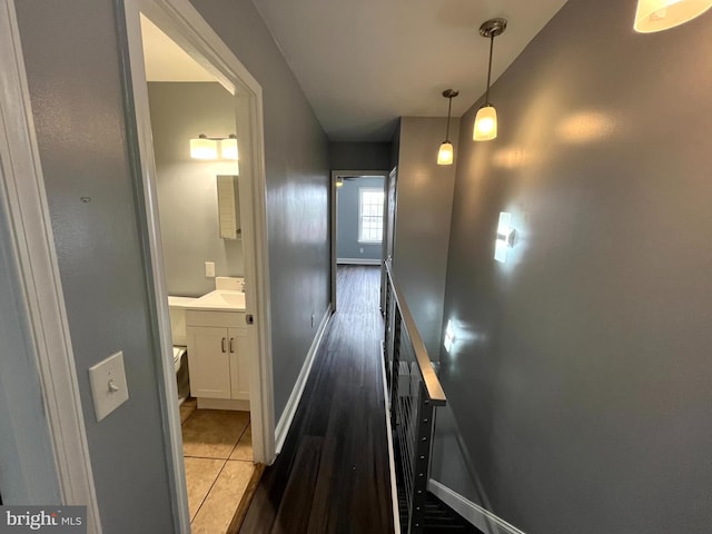 corridor featuring baseboards and light tile patterned floors