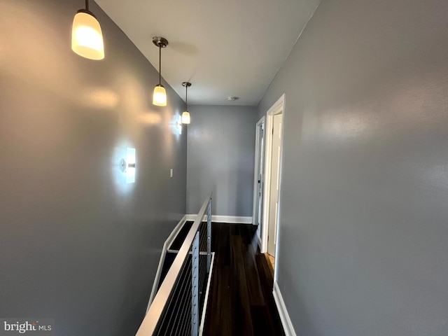 corridor featuring dark wood-style floors and baseboards
