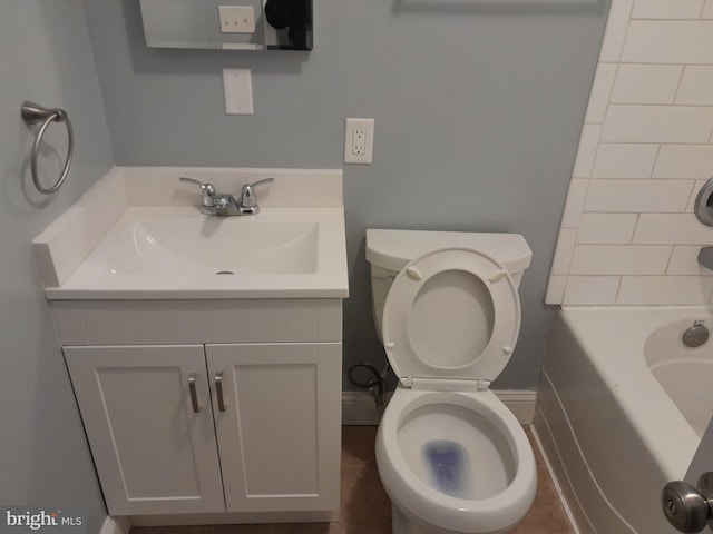 bathroom with vanity, a tub to relax in, and toilet