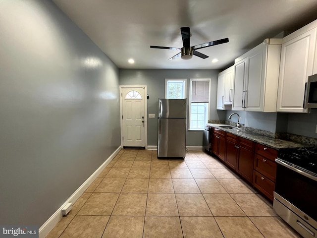 120 S Haven St, Baltimore, MD 21224 - kitchen with appliances with stainless steel finishes, a sink, ceiling fan, white cabinets, and light tile patterned flooring