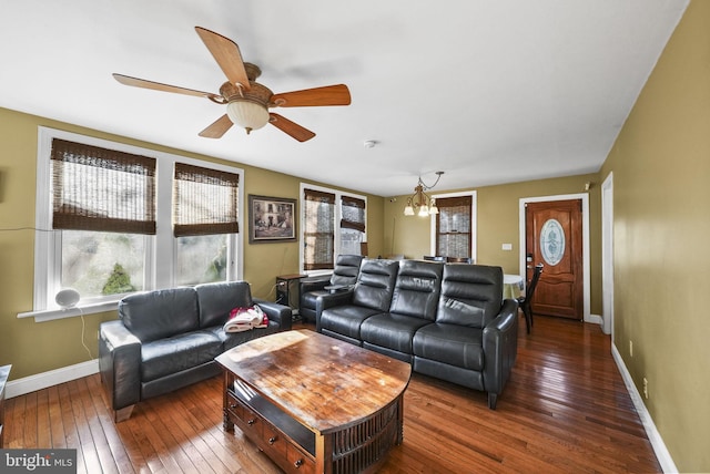 living room with ceiling fan with notable chandelier and hardwood / wood-style flooring