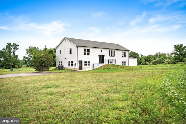 back of house featuring a yard and central air condition unit