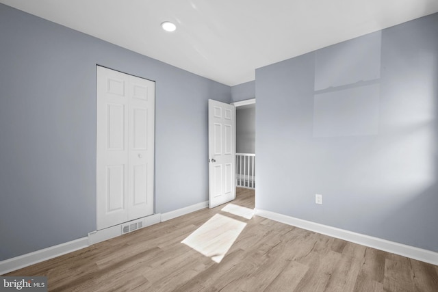 unfurnished bedroom with light hardwood / wood-style floors and a closet