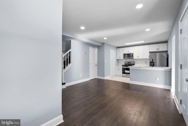 kitchen featuring white cabinets, hardwood / wood-style flooring, and appliances with stainless steel finishes