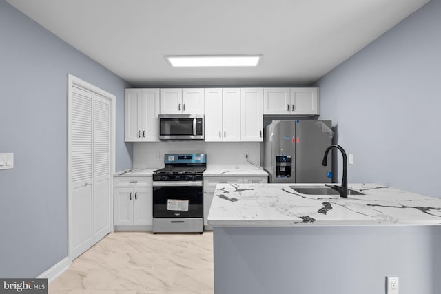 kitchen featuring white cabinets, sink, light stone counters, kitchen peninsula, and stainless steel appliances