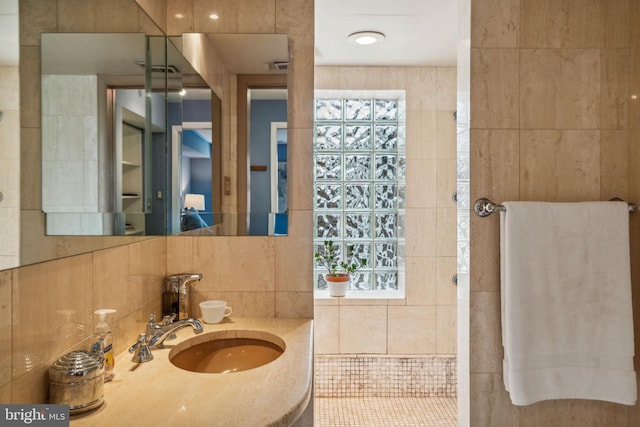 bathroom featuring sink and tile walls