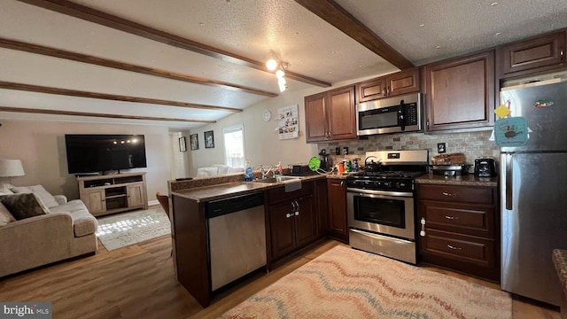 kitchen with kitchen peninsula, stainless steel appliances, light hardwood / wood-style floors, decorative backsplash, and dark brown cabinets