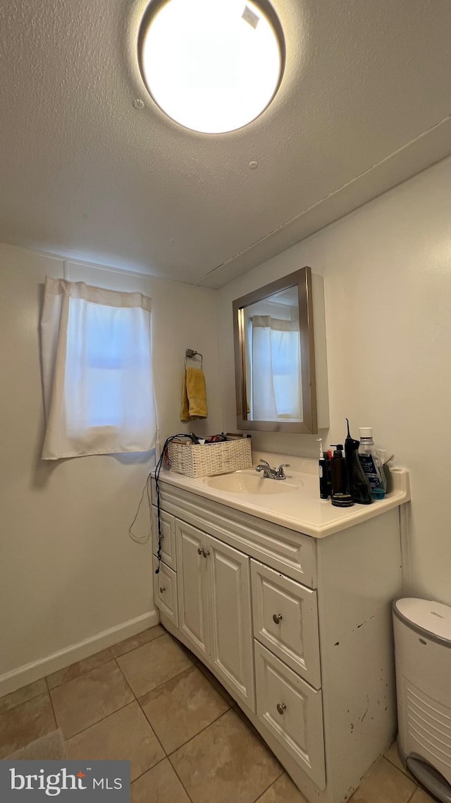 bathroom with tile patterned flooring, vanity, and a textured ceiling