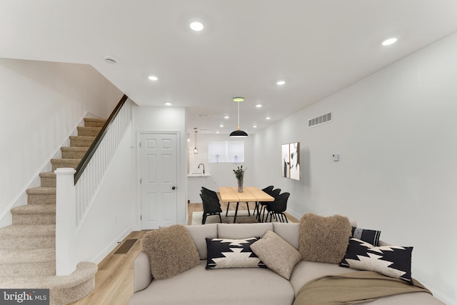 living room featuring light hardwood / wood-style floors and sink