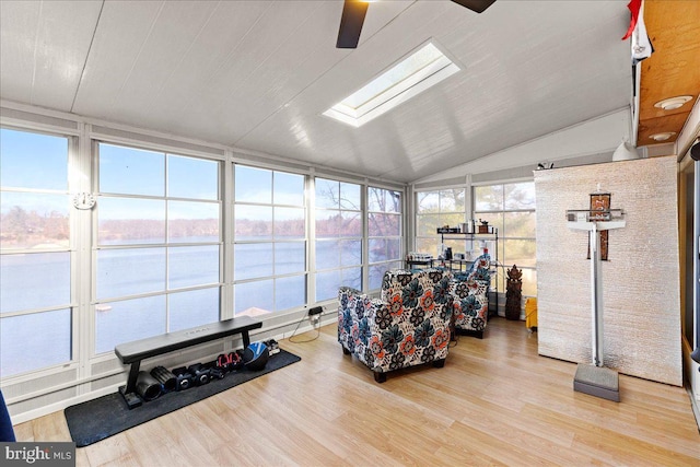 sunroom with ceiling fan, vaulted ceiling with skylight, and a water view