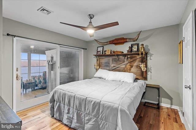 bedroom featuring access to outside, ceiling fan, a water view, and light hardwood / wood-style floors