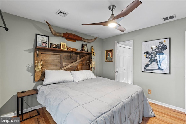 bedroom with a closet, light hardwood / wood-style floors, and ceiling fan