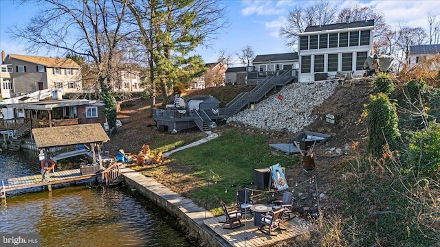 back of property featuring a sunroom and a water view