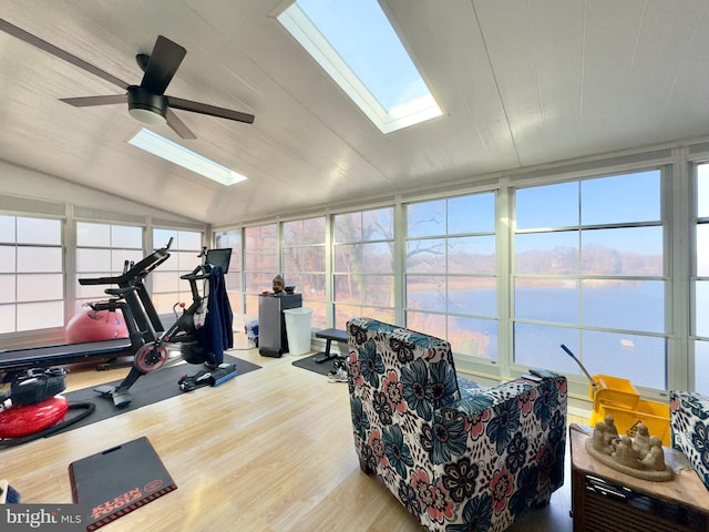 exercise room with a wealth of natural light, ceiling fan, and a water view