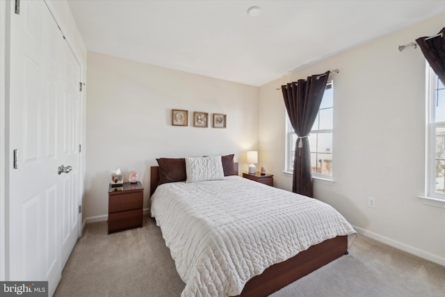 bedroom with light carpet and multiple windows