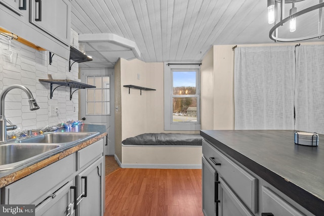 kitchen with gray cabinetry, wood-type flooring, sink, and wooden ceiling