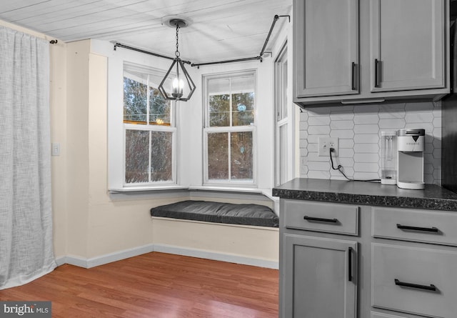 kitchen with backsplash, gray cabinets, hardwood / wood-style floors, and pendant lighting