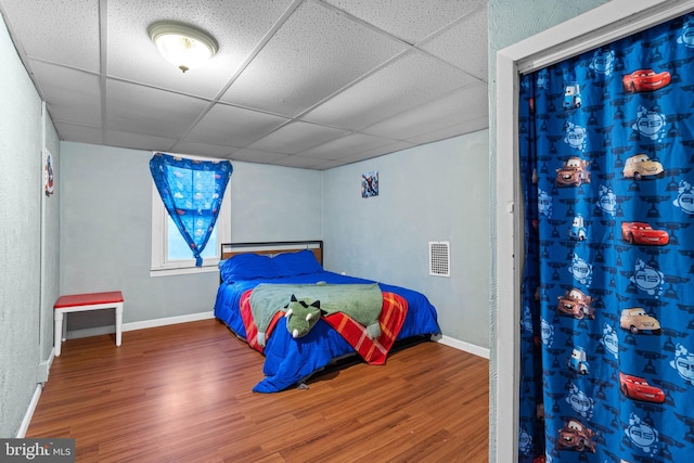 bedroom featuring a paneled ceiling and hardwood / wood-style flooring