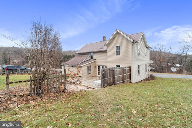 back of house featuring a lawn and a patio area