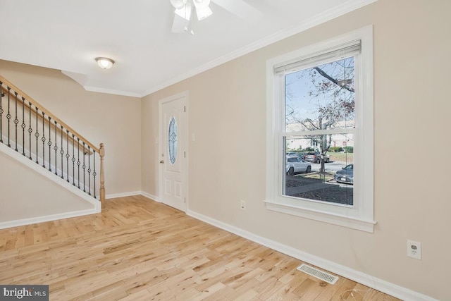 foyer entrance with light hardwood / wood-style flooring, ceiling fan, and crown molding