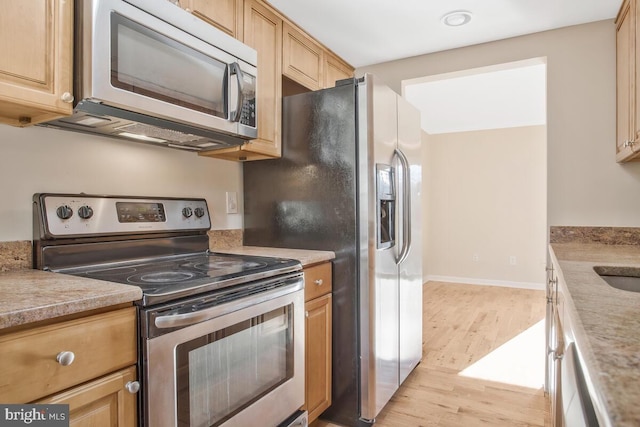 kitchen with light hardwood / wood-style floors, light brown cabinetry, sink, and appliances with stainless steel finishes