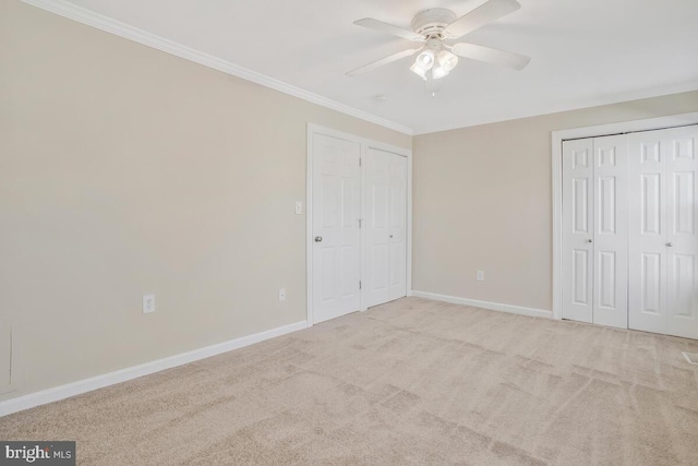 unfurnished bedroom with ceiling fan, light colored carpet, and crown molding