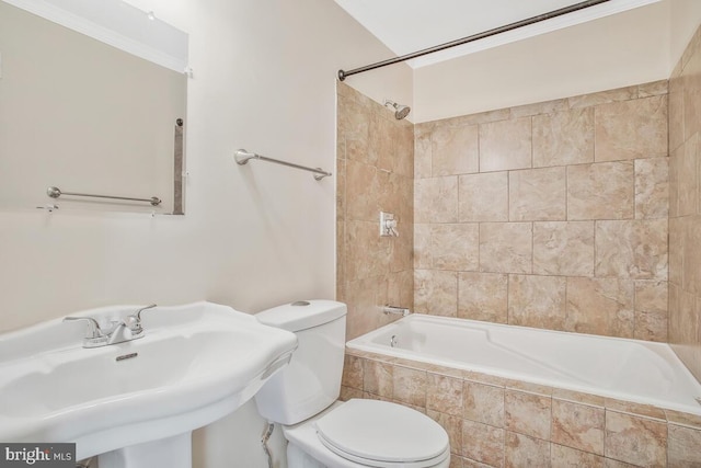 full bathroom featuring toilet, tiled shower / bath, and sink