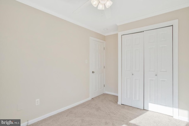 unfurnished bedroom with light colored carpet, a closet, ornamental molding, and ceiling fan