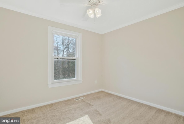 spare room featuring light carpet, crown molding, and ceiling fan