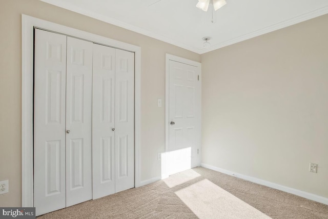 unfurnished bedroom with ceiling fan, a closet, light colored carpet, and ornamental molding