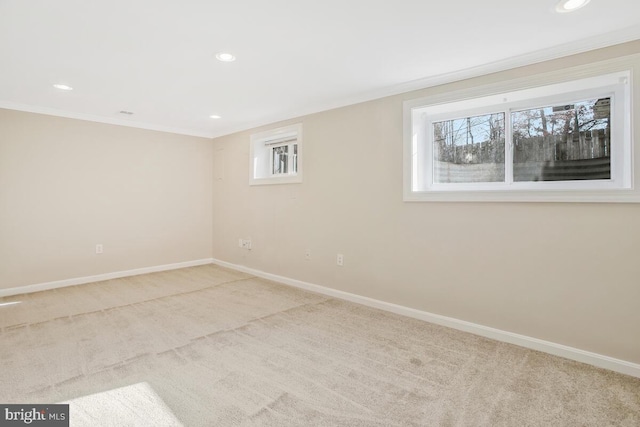 spare room featuring ornamental molding, light carpet, and a wealth of natural light