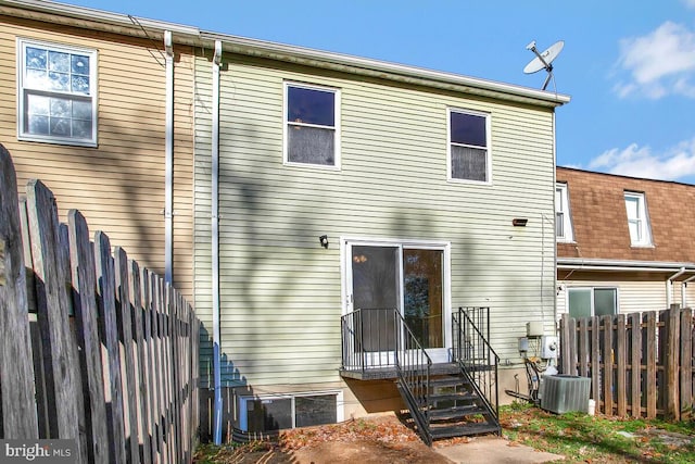 rear view of property with cooling unit