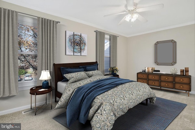 carpeted bedroom with ceiling fan and ornamental molding