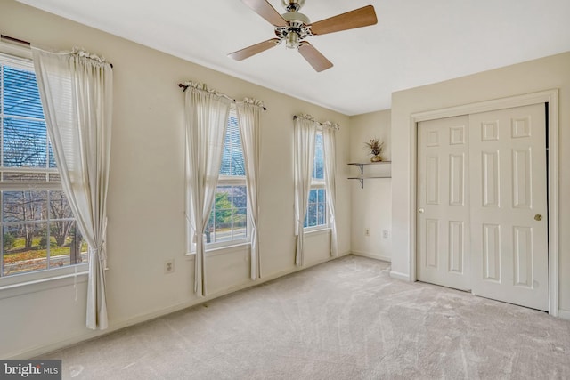 unfurnished bedroom with a closet, ceiling fan, and light colored carpet