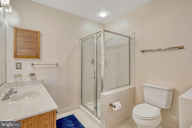 bathroom featuring tile patterned flooring, vanity, an enclosed shower, and toilet